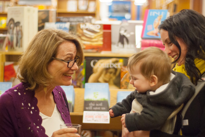 Photo of Kristin Ohlson chatting with a family - Photo by Kristin Beadle